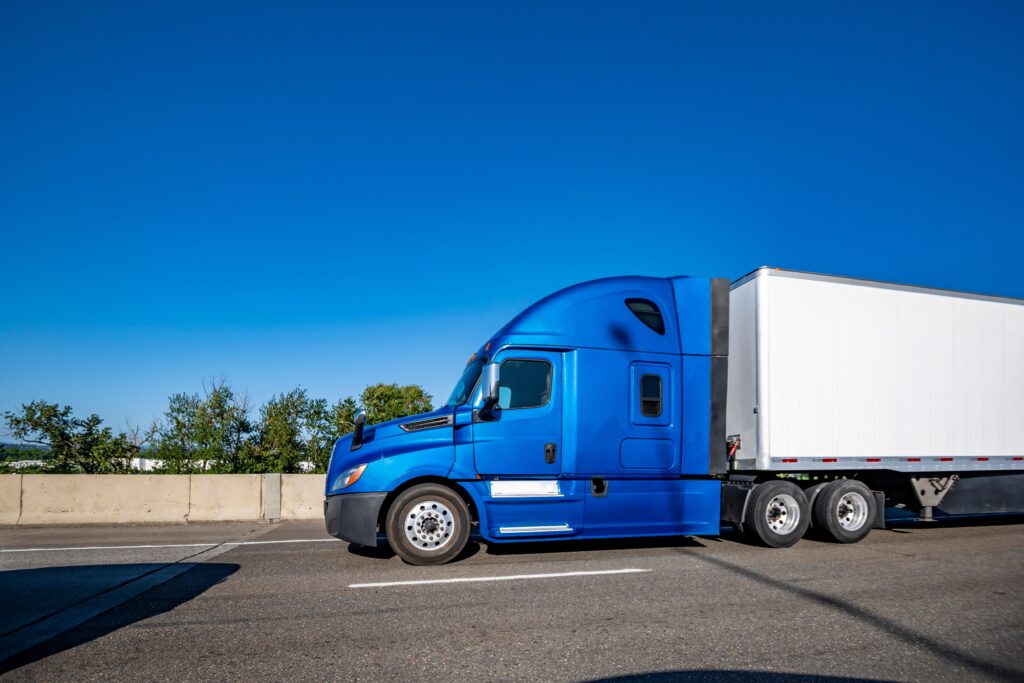 Blue semi-cab pulling tractor-trailer on highway